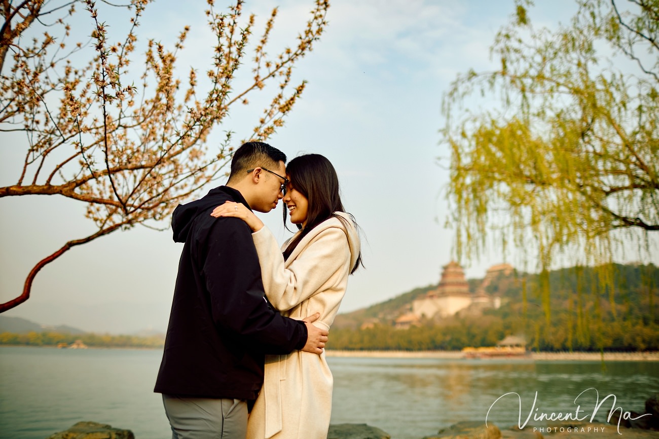 Breathtaking moment of a secret proposal at the Summer Palace, Beijing. A man on one knee amidst spring flowers and ancient imperial architecture. Captured by Beijing photographer Vincent Ma.