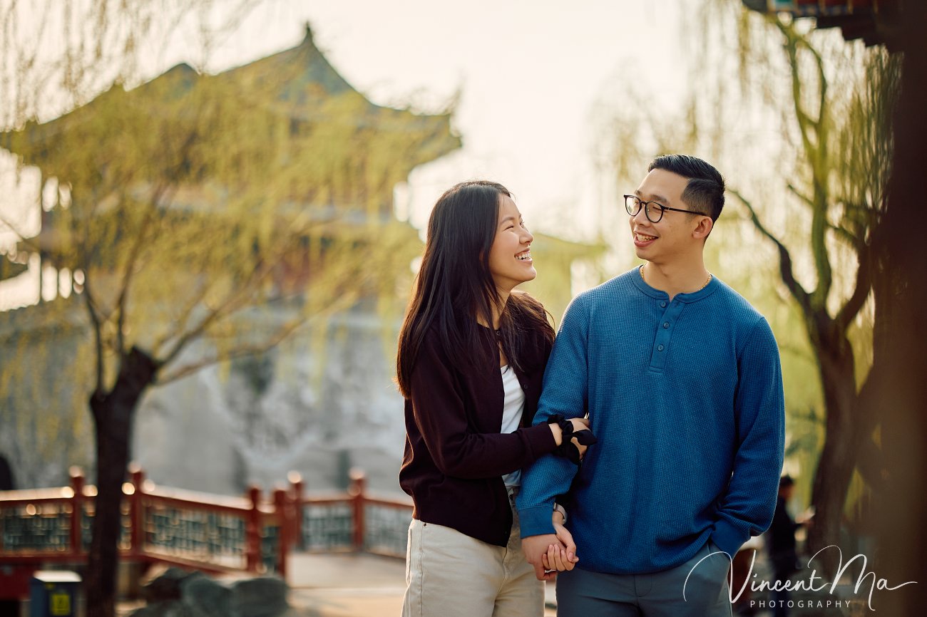 Breathtaking moment of a secret proposal at the Summer Palace, Beijing. A man on one knee amidst spring flowers and ancient imperial architecture. Captured by Beijing photographer Vincent Ma.