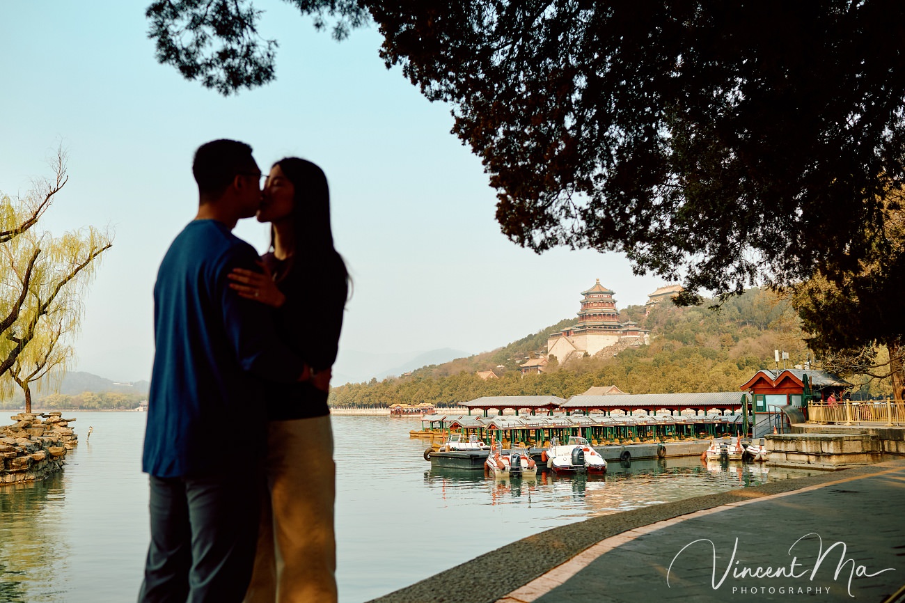 Breathtaking moment of a secret proposal at the Summer Palace, Beijing. A man on one knee amidst spring flowers and ancient imperial architecture. Captured by Beijing photographer Vincent Ma.