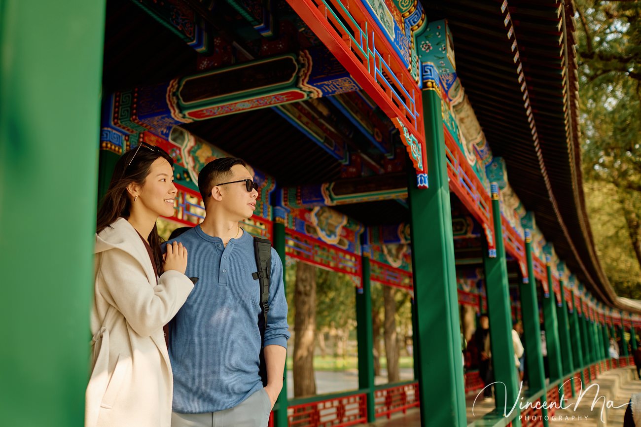 A cinematic capture of a secret proposal at the Summer Palace, Beijing. The couple is framed by blooming cherry blossoms and magnolias with the Tower of Buddhist Incense in the background. Professional photography by Vincent Ma for an American couple's first trip to China.